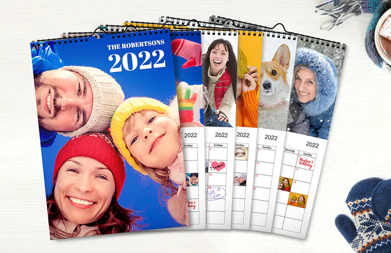 Calendario fotografico 2020 personalizzato da appendere al muro di Printerpix|Foto della fidanzata su calendario da parete personalizzato appeso in soggiorno|Donna che scrive su calendario da parete personalizzato A4 di printerpix con foto a tema natalizio|Calendario da parete A3 2020 appeso con design fotografico personalizzato di printerpix|Coppia romantica in soggiorno con calendario da parete personalizzato 2020 con foto di proposta|Foto di cani su calendario fotografico di design personalizzato appeso al muro