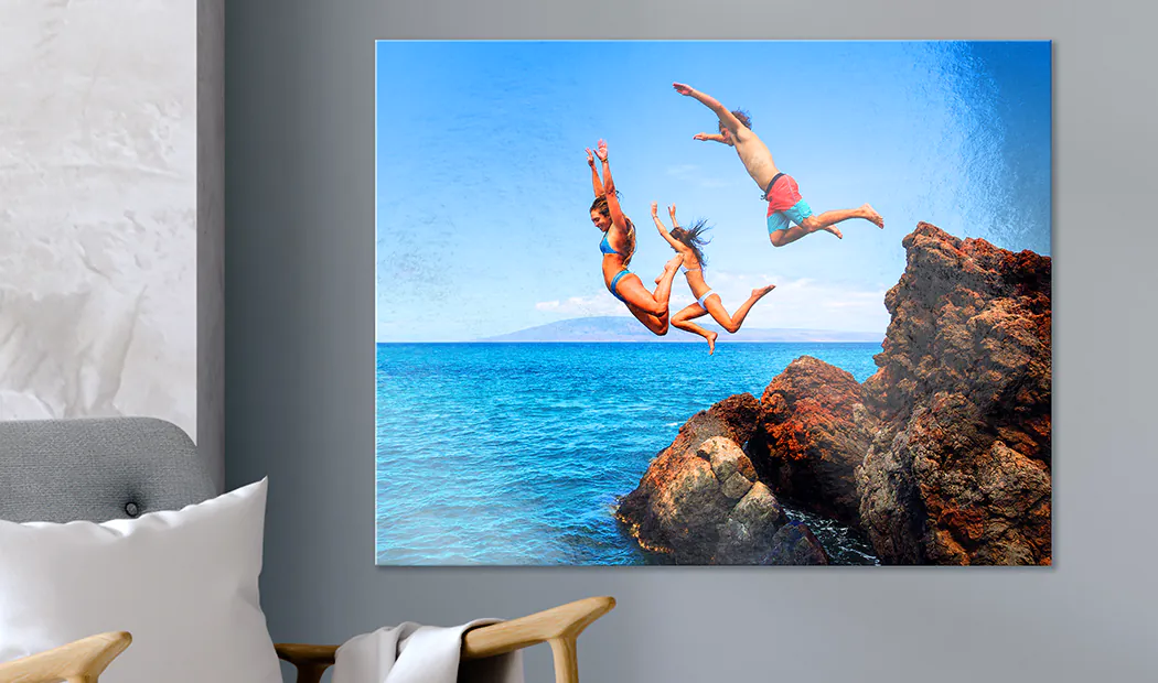 Stampa fotografica in metallo personalizzata: Tre amici saltano dalle rocce in un oceano turchese vibrante. Un pezzo straordinario e su misura per la tua casa.