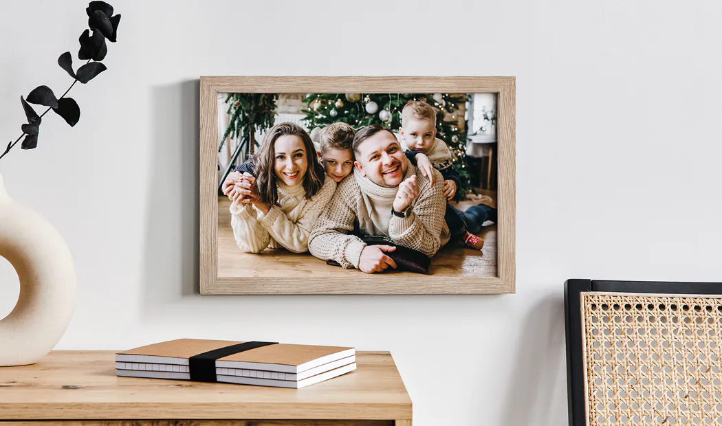 Stampa incorniciata personalizzata di Natale in famiglia: famiglia felice di quattro persone vicino all'albero. Atmosfera calda e festosa.