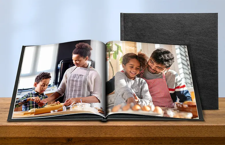 Album fotografico personalizzato aperto sul tavolo con collage di foto di famiglia