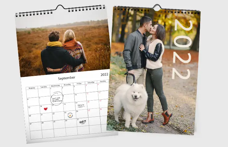 Donna che scrive su calendario da parete personalizzato A4 di printerpix con foto a tema natalizio
