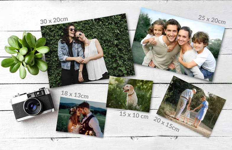 Stampe fotografiche piccole, medie e grandi sul tavolo dal telefono cellulare