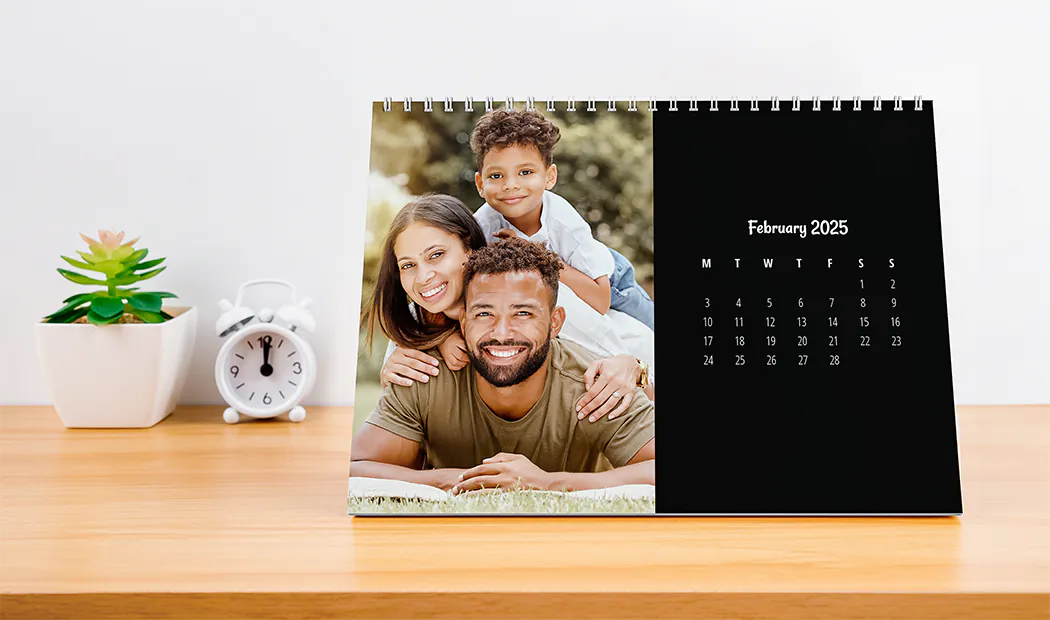 Donna che scrive su calendario da parete personalizzato A4 di printerpix con foto a tema natalizio