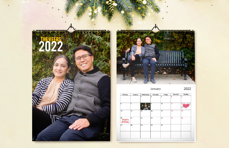 Donna che scrive su calendario da parete personalizzato A4 di printerpix con foto a tema natalizio