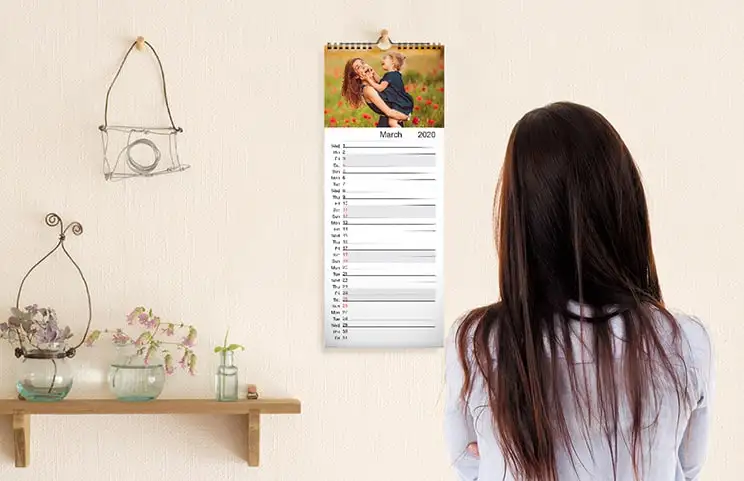 Calendario da cucina appeso alla parete della cucina con foto delle vacanze in famiglia