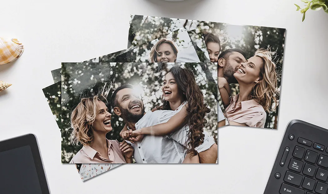 Mani che tengono una stampa fotografica di tre bambini in vacanza
