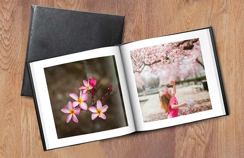 Coppia guarda libro fotografico personalizzato con copertina in pelle realizzato da Printerpix