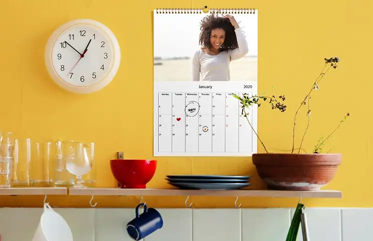 Coppia romantica in soggiorno con calendario da parete 2020 personalizzato con foto di proposta