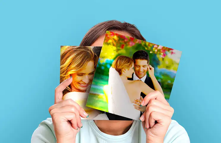 Donna che tiene due stampe fotografiche di matrimonio su metallo