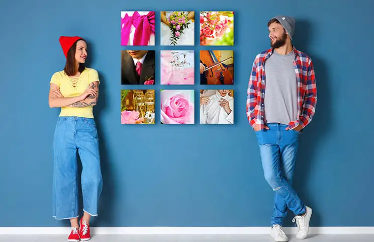 Coppia davanti a un muro blu con nove tele fotografiche quadrate